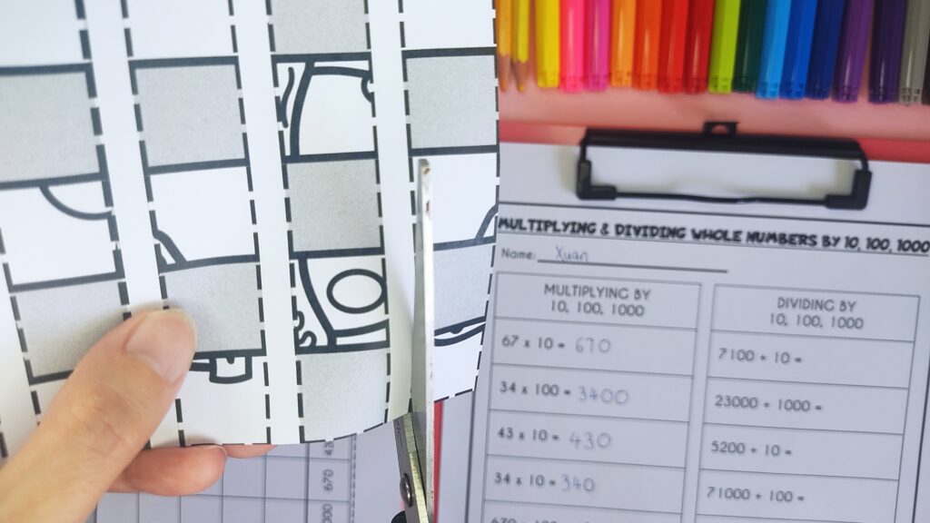 student cutting along the dotted line of the template for paper weaving.